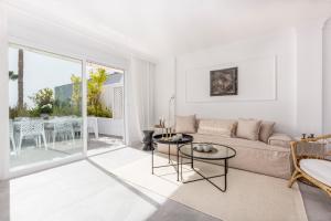 biały salon z kanapą i stołem w obiekcie Bella Vista Puerto Banus apartment with sea views w Marbelli