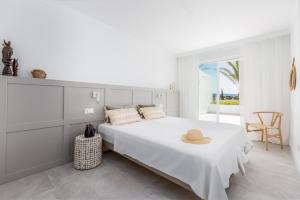 biała sypialnia z łóżkiem z kapeluszem w obiekcie Bella Vista Puerto Banus apartment with sea views w Marbelli +19 zdjęć