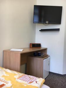 a room with a bed and a tv on a wall at Piast Hotele Studenckie in Krakow