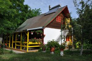 a house with a gambrel roof with flowers and plants at Pensiunea Rustic in Eforie Sud