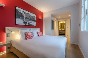 a bedroom with a large white bed with red walls at Hotel Villa Koegui Biarritz in Biarritz +50 photos