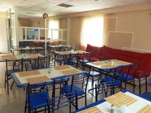 a dining room with tables and blue chairs at Максим in Gelendzhik