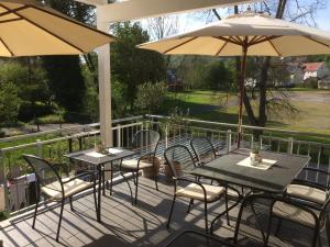 2 mesas y sillas con sombrillas en un patio en Haus 8, en Lauterecken