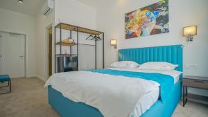a bedroom with a blue bed with a blue head board at Zoom Rooms in Braşov