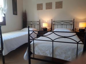two beds in a bedroom with two lamps on them at Villa Del Lago Boutique Hotel in Kastoria