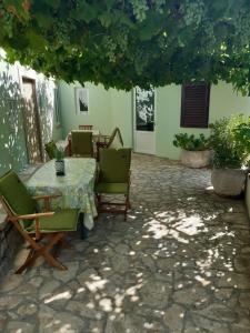 a patio with a table and chairs in a yard at Apartment Mirjana in Nerezine