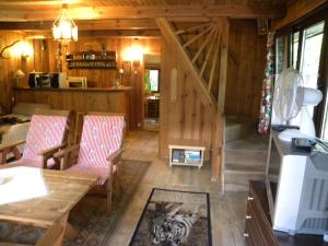 een woonkamer met 2 stoelen en een trap in een hut bij Dom letniskowy in Różan
