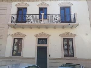 een wit gebouw met een balkon en een deur bij Funny Flat in Paterno