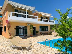 a villa with a swimming pool in front of a house at Aegli in Vasiliki