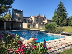 a swimming pool in front of a house at Gîte et maison de vacances Campagne Valérie in Aix-en-Provence