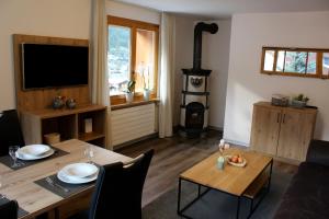 uma sala de estar com uma mesa e um fogão a lenha em Haus Les Mélèzes em Zermatt