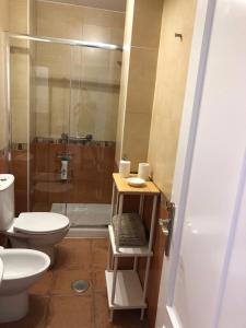 a bathroom with a toilet and a sink and a shower at Chipiona Acogedor in Chipiona +17 photos