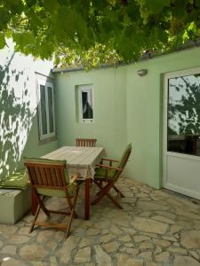 a wooden table and two chairs on a patio at Apartment Mirjana in Nerezine