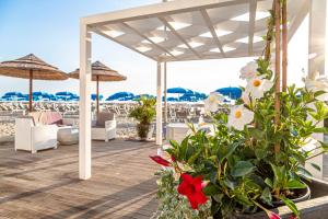 un patio con flores y sombrillas en la playa en Evo Boutique Hotel & SPA en Bellaria-Igea Marina