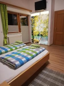 - une chambre avec 2 lits et une grande fenêtre dans l'établissement Gästehaus Ferner, à Sankt Michael im Lungau