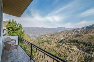 a balcony with a chair and a view of the mountains at The Brigadiers Cottage, Mussoorie in Mussoorie