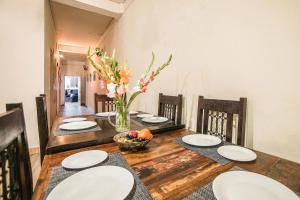 a dining room with a wooden table with white plates on it at The Brigadiers Cottage, Mussoorie in Mussoorie