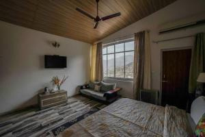 una camera con un letto e una sedia e una finestra di The Brigadiers Cottage, Mussoorie a Mussoorie
