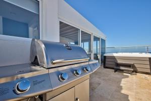 a grill on the balcony of a house at Valletta Luxury 4-Bedroom Duplex with Stunning Sea Views Private Terrace and Jacuzzi in Valletta