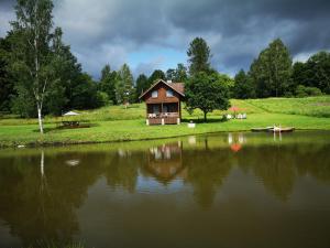 uma pequena casa na margem de um lago em Atpūtas vieta Upes Sausītes em Sidrabiņi