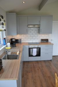 cocina con electrodomésticos blancos y suelo de madera en Glencoe view lodge, en Glencoe