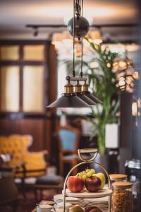 a bowl of fruit on a table with a light at HENRI Hotel Wien Siebterbezirk in Vienna
