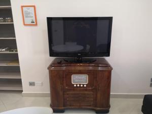 een televisie bovenop een houten standaard bij Funny Flat in Paterno