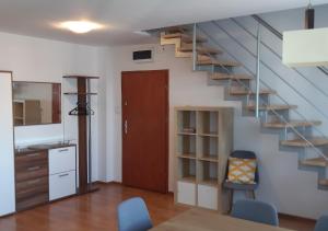 a living room with a staircase and a table and chairs at Apartament dwupoziomowy in Augustów