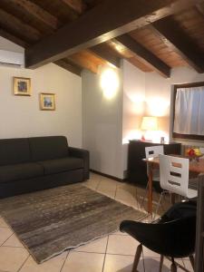 a living room with a couch and a tv at Holiday Confort La Volta in Brescia