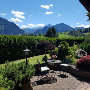 a patio with a table and chairs and mountains at Ferienwohnung Alpenrose in Goldegg