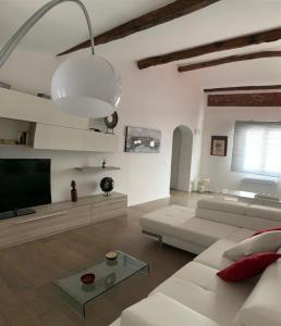 sala de estar con sofá blanco y TV de pantalla plana en Ca' del Grillo, en La Spezia