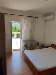 a bedroom with a bed and a sliding glass door at Tonica Put rive 17 in Metajna