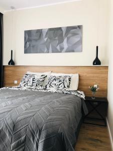a bedroom with a large bed with a wooden headboard at DOBRY MOMENT - apartament Giżycko in Giżycko