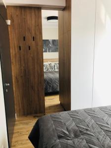 um quarto com uma porta que leva a uma cama em DOBRY MOMENT - apartament Giżycko em Giżycko