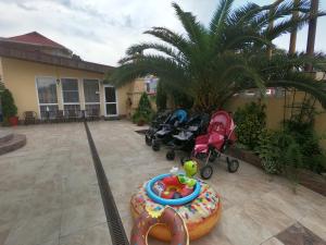 um quintal com dois carrinhos de bebé e um parque infantil em Orange House Guest House em Adler