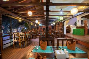 un ristorante con tavoli e sedie in legno e luci di Landmark Pokhara a Pokhara