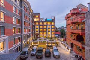 a parking lot with cars parked in front of a building at Landmark Pokhara in Pokhara