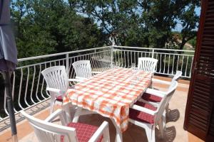 a table and chairs sitting on a balcony with a table and chairs at Apartman Svjetličić in Brzac