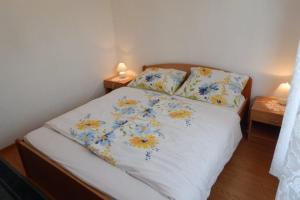 um quarto com uma cama com flores em Apartman Svjetličić em Brzac