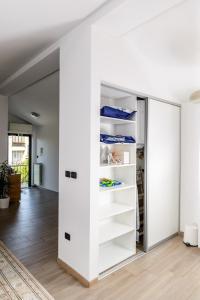 Cette chambre comprend un placard blanc avec des étagères. dans l'établissement Istriana boutique apartment, à Nova Gorica