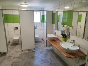 a bathroom with two sinks and two toilets at Gasthof Schwanen Radelfingen in Radelfingen +25 photos