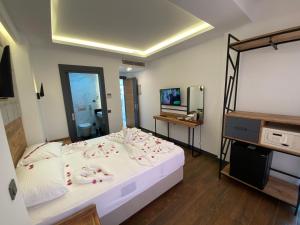 a bedroom with a bed with a mirror and a television at MİYAS LUXURY HOTEL in Kemer