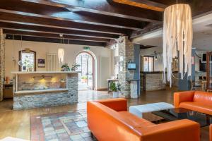 a living room with orange furniture and a stone fireplace at Il Lavatoio Dimora Storica in Castel di Sangro