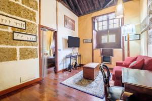 ein Wohnzimmer mit einem roten Sofa und einem TV in der Unterkunft Casa Tradicional Canaria - D in Garachico