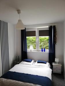 1 dormitorio con cama y ventana en REDA - Pokoje z niezależnym wejściem, en Międzywodzie