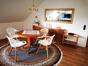 a dining room with a table and chairs and a mirror at Ferienwohnungen und Ferienhaus im Nixenweg in Hohwacht