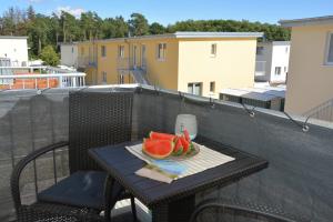 a plate of watermelon on a table on a balcony at Ostsee-Karo, inklusive Bettwäsche und Handtücher in Graal-Müritz