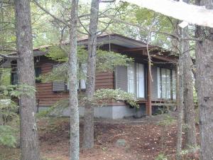 una casa di legno con alberi di fronte di Cottage Karuizawa a Karuizawa