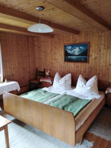 ein großes Bett in einem Zimmer mit Holzwänden in der Unterkunft Ferienhaus Lederer in Stockenboi