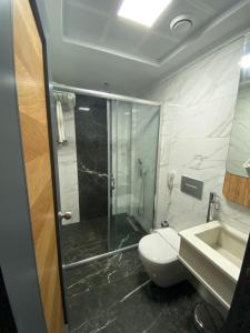 a bathroom with a shower and a toilet and a sink at MİYAS LUXURY HOTEL in Kemer
